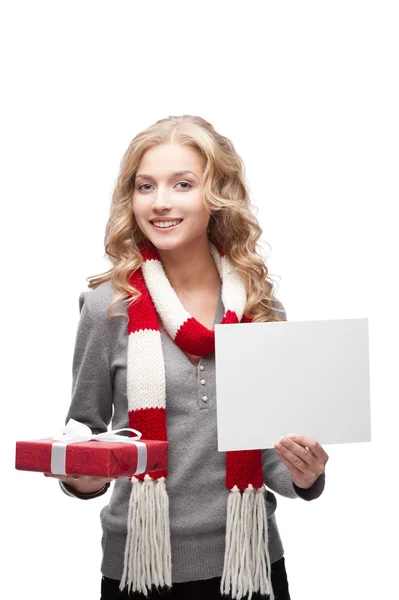 Usmívající se žena drží vánoční dárek a znamení — Stock fotografie