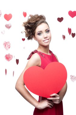 Kırmızı kağıt kalp tutan neşeli genç kadın