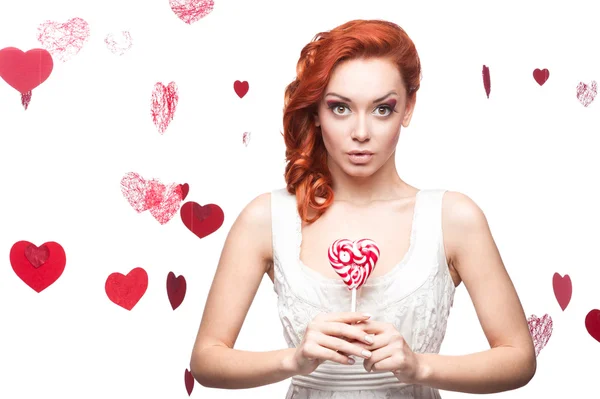 Surprised red-haired woman holding lollipop — Stock Photo, Image