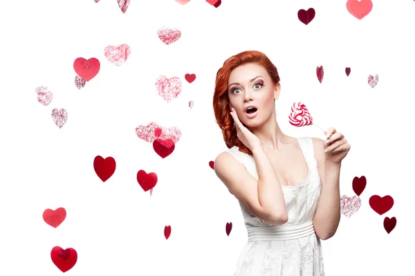 Surprised red-haired woman holding lollipop — Stock Photo, Image