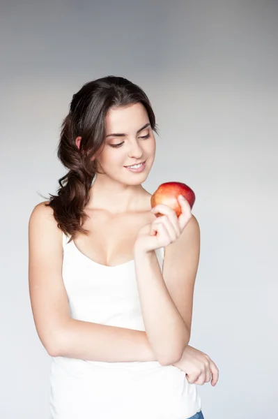 Thoughtful girl holding apple — Stock Photo, Image