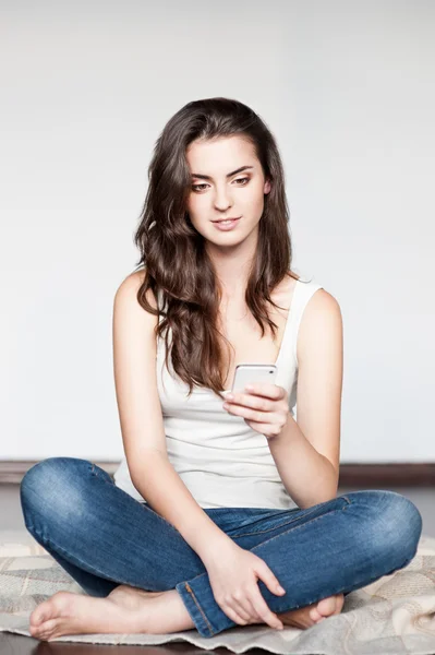 Casual brunette girl holding cell phone — Stock Photo, Image