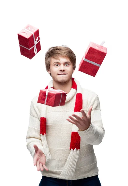 Young funny man juggle the christmas gifts — Stock Photo, Image