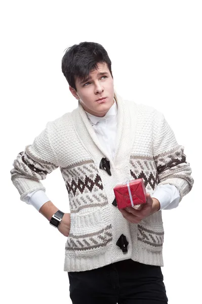Nachdenklicher junger Mann in Winterkleidung hält Geschenk in der Hand — Stockfoto