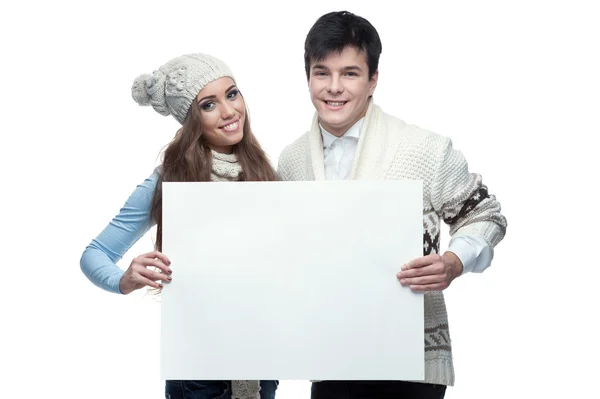 Young smiling winter couple holding big sign — Stock Photo, Image