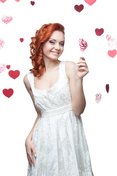 Surprised red-haired woman holding lollipop — Stock Photo, Image