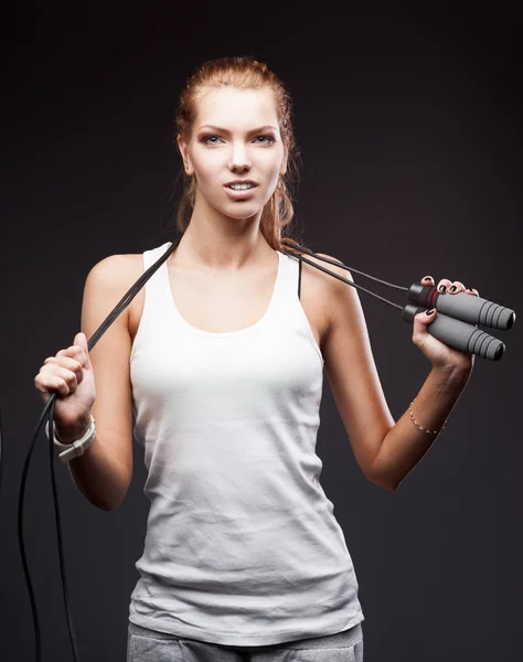 Meisje met springen-rope op donkere achtergrond — Stockfoto