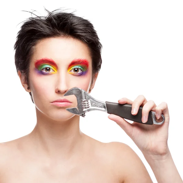 Beautiful woman with fantasy makeup holding wrench — Stock Photo, Image