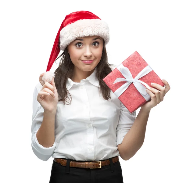 Junge fröhliche Geschäftsfrau mit Weihnachtsmann-Hut hält Weihnachtsgeschenk in der Hand — Stockfoto