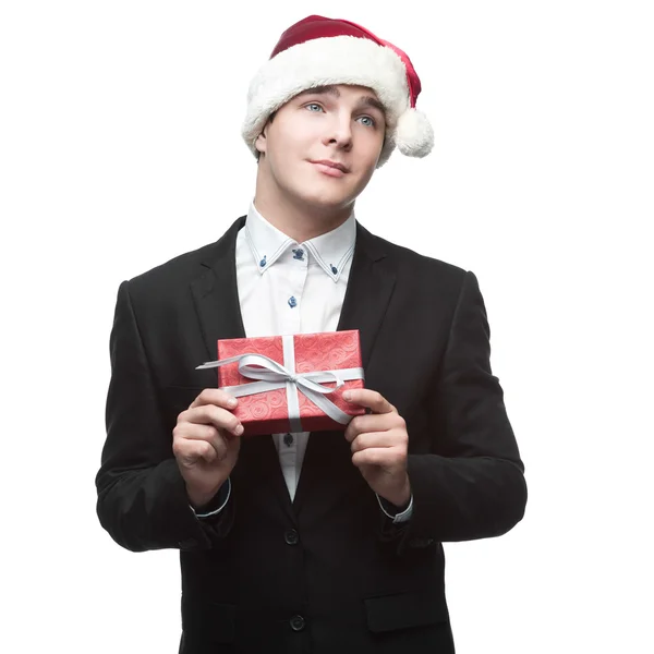 Funny businessman in santa hat holding gift — Stock Photo, Image