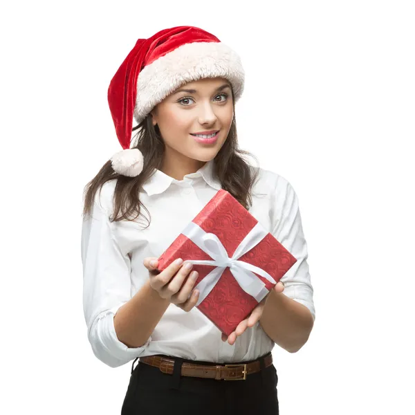 Junge fröhliche Geschäftsfrau mit Weihnachtsmann-Hut hält Weihnachtsgeschenk in der Hand — Stockfoto