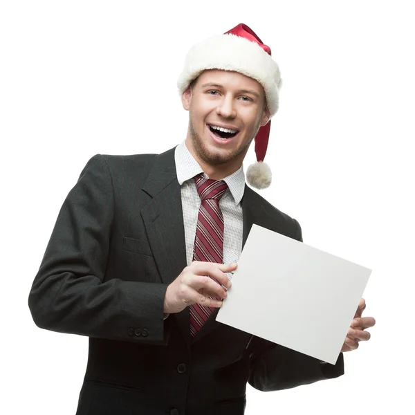 Joven sonriente hombre de negocios en santa hat sosteniendo cartel — Foto de Stock