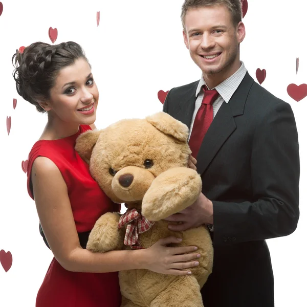 Smiling elegant couple holding big soft toy — Stock Photo, Image