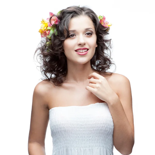 Smiling young woman with flower in hair — Stok fotoğraf