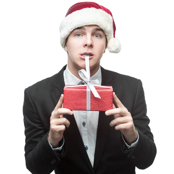 Funny businessman in santa hat biting red gift — Stock Photo, Image