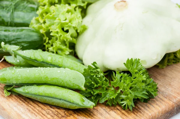 Gröna ärtor pods liggande med grönska — Stockfoto