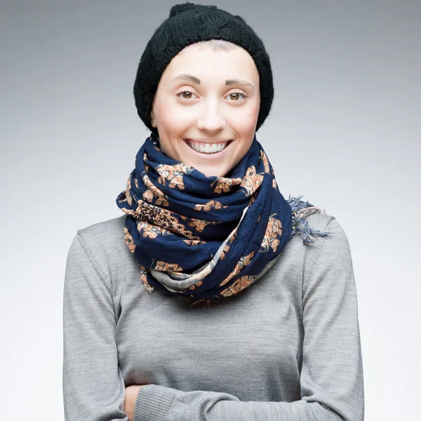 Young cheerful girl in winter clothing on gray — Stock Photo, Image