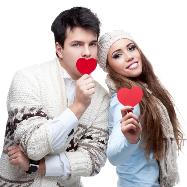 Cheerful casual young couple holding red hearts — Stock Photo, Image
