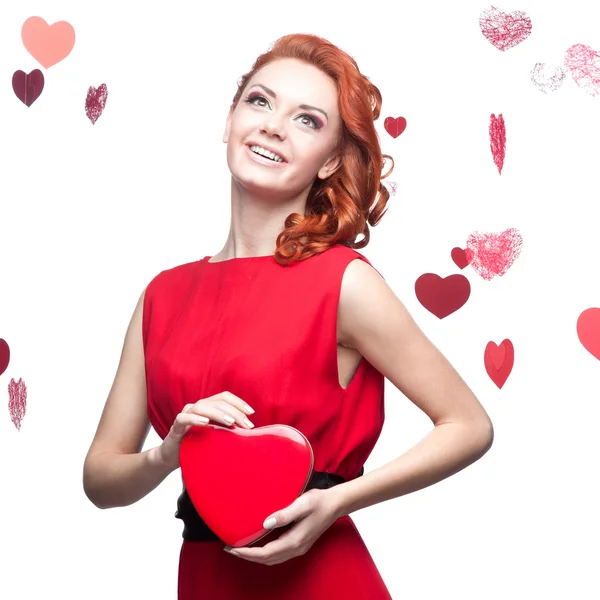 Smiling red-haired girl holding red heart — Stock Photo, Image