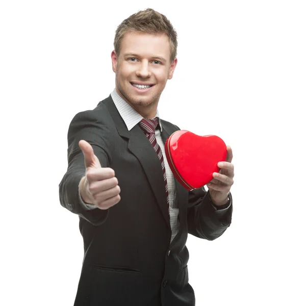 Jeune homme d'affaires joyeux tenant coeur rouge — Photo