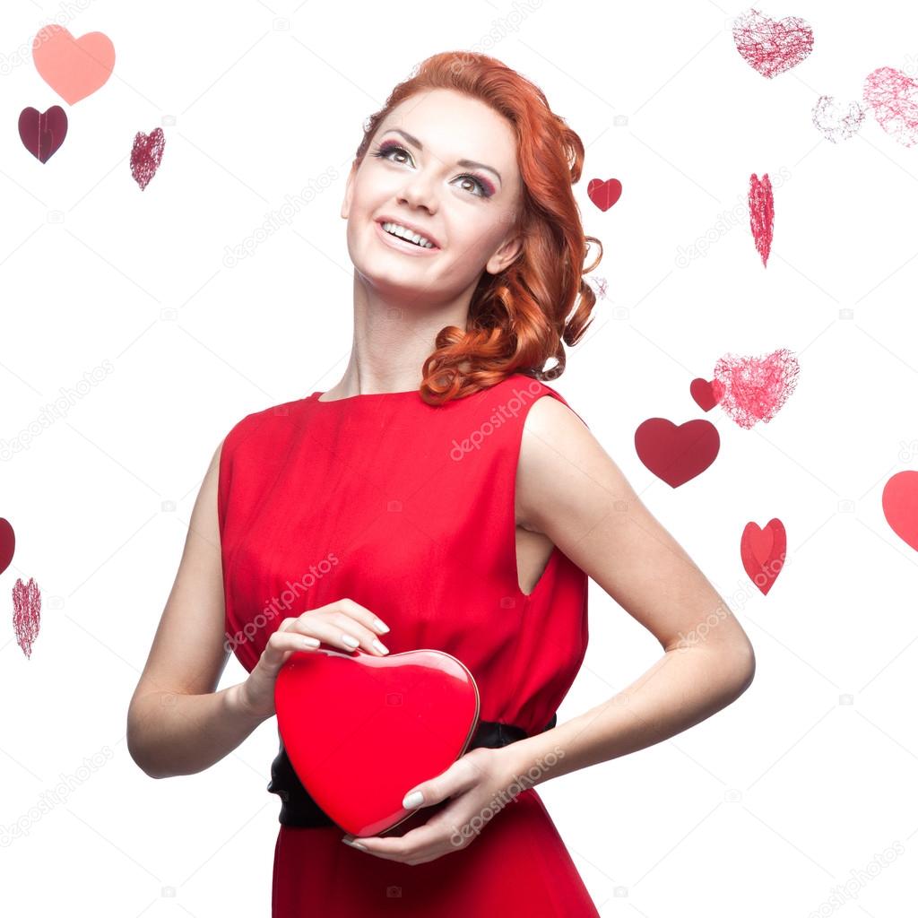 smiling red-haired girl holding red heart
