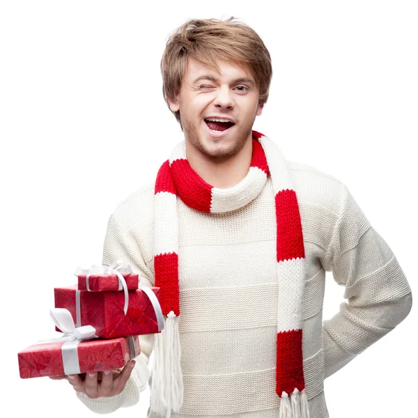 Young winking man holding christmas gifts — Stock Photo, Image