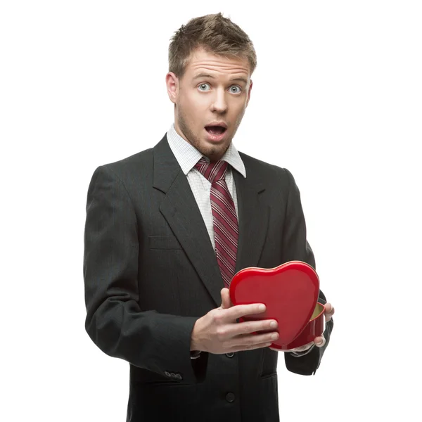 Young surprised businessman holding red heart — Stock Photo, Image