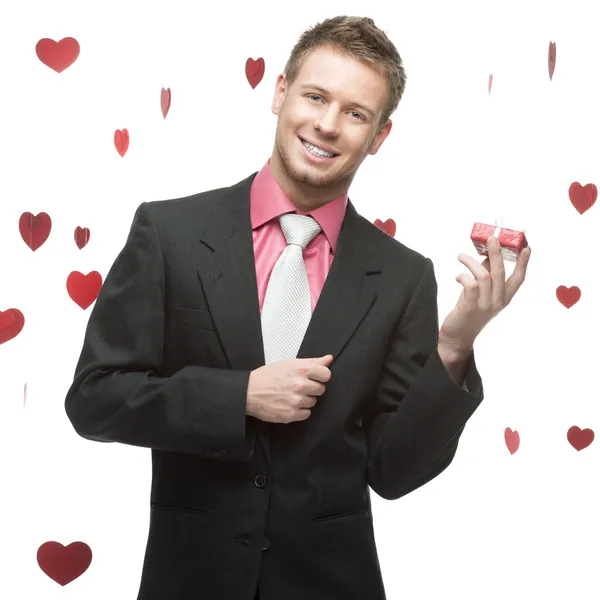 Young cheerful businessman holding red gift — Stock Photo, Image