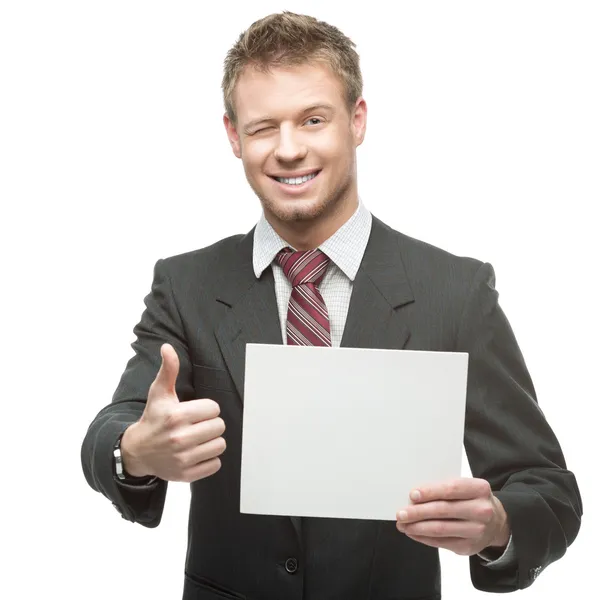 Cheerful winking businessman holding sign — Stock Photo, Image
