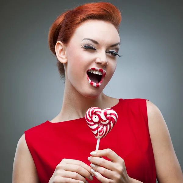 Grappig roodharige meisje bedrijf snoep — Stockfoto