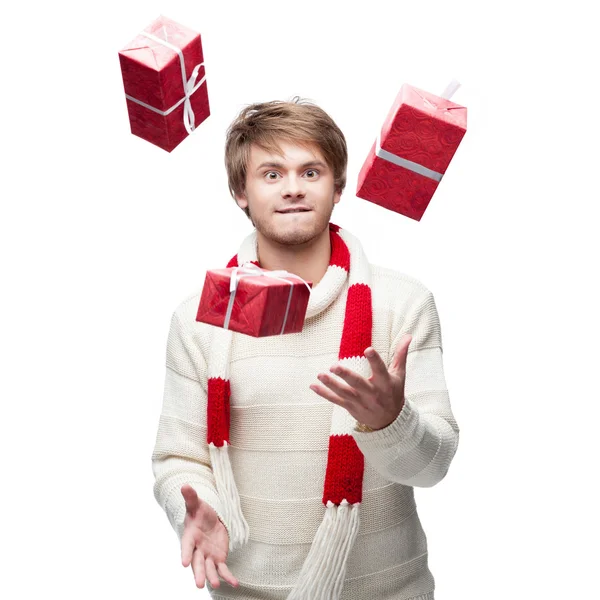 Jovem homem engraçado malabarismos os presentes de Natal — Fotografia de Stock