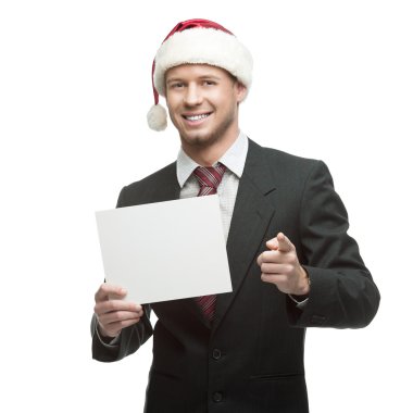 genç gülümseyen iş adamı işaret tutan Noel Baba şapkası