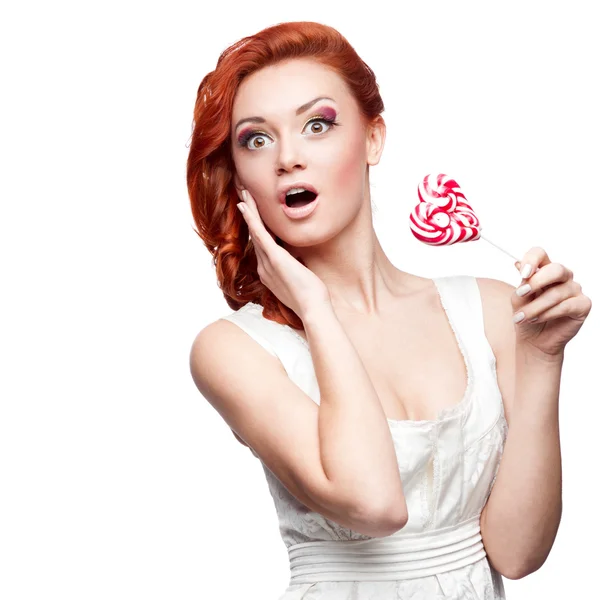 Verrast roodharige vrouw bedrijf lolly — Stockfoto