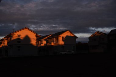 Şafak vakti. Sabah güneşinde bir ev.