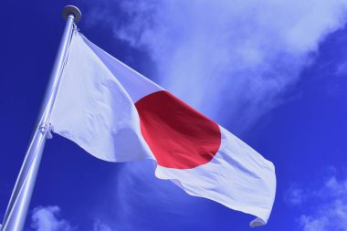 Japanese flag fluttering in the wind. In Japan, it is called 'Hinomaru' and symbolizes the rising sun. Red and white are traditional Japanese colors and are considered auspicious.