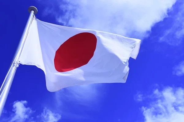 Japanese flag fluttering in the wind. In Japan, it is called 'Hinomaru' and symbolizes the rising sun. Red and white are traditional Japanese colors and are considered auspicious.