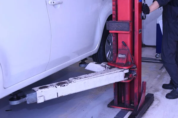 A scene of tire replacement work at a car repair shop.