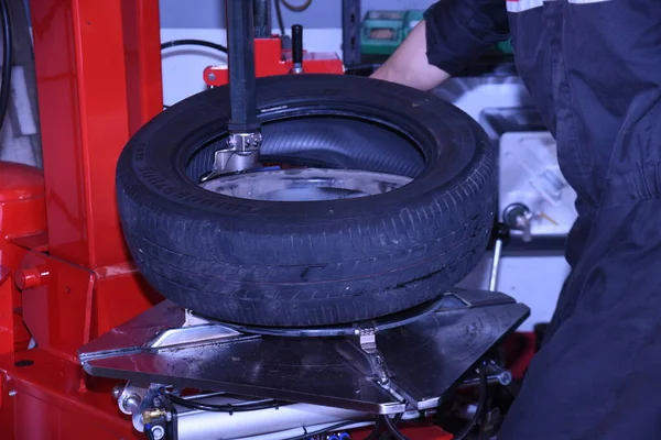 A scene of tire replacement work at a car repair shop.