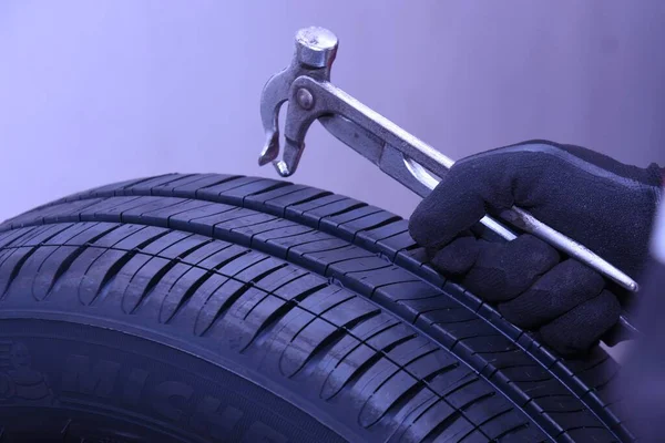 A scene of tire replacement work at a car repair shop.