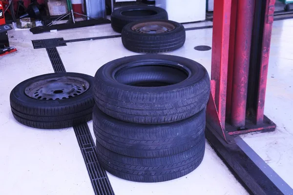 A scene of tire replacement work at a car repair shop.