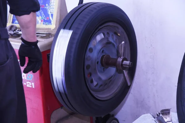 A scene of tire replacement work at a car repair shop.