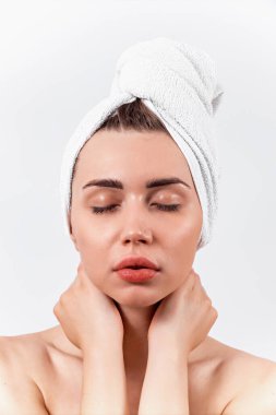 Beyaz havluyla güzel esmer kız beyaz arka planda duruyor.