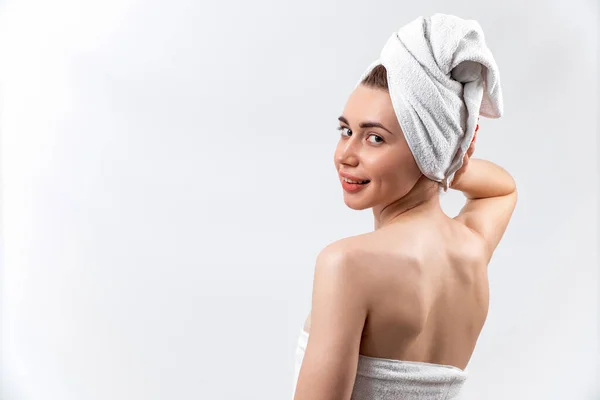 Красивая брюнетка девушка в белом полотенце стоит на белом фоне — стоковое фото