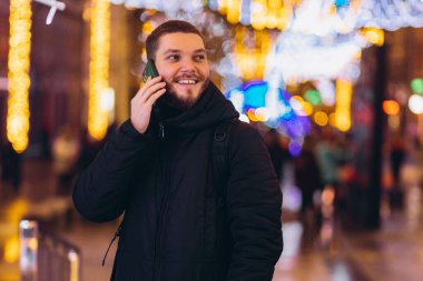 Bir adam telefonla arıyor. Gece şehri. kış