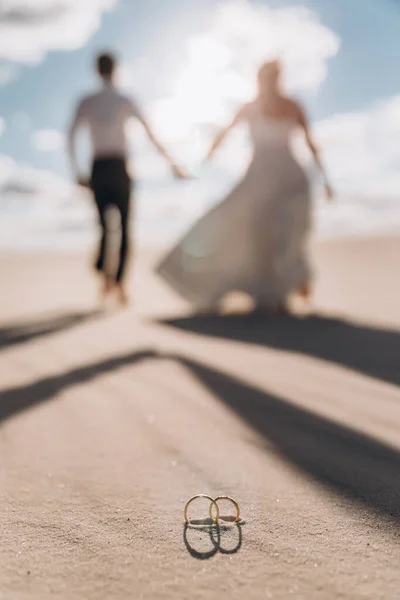 Esküvői Pár Távolba Megy Sivatag Hátterében Gyűrűk Közelkép Előtérben — Stock Fotó