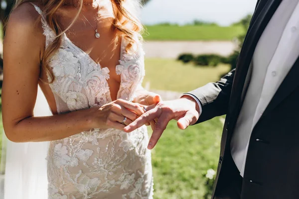 Közelkép a vőlegény felteszi a jegygyűrűt az ujját a menyasszony az ünnepségen — Stock Fotó