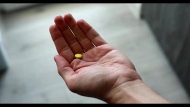 Bir erkeğin elinde birçok hap ve vitamin vardır, POV, birinci şahıs görünümü