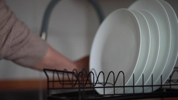 Крупным планом женщина моет посуду на кухне и ставит сушить — стоковое видео