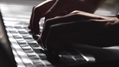 Dizüstü bilgisayarın klavyesine erkek eli yakın çekim. Daktilo, şifre, programlama.