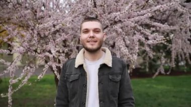 Genç adam kameraya gülümsüyor.